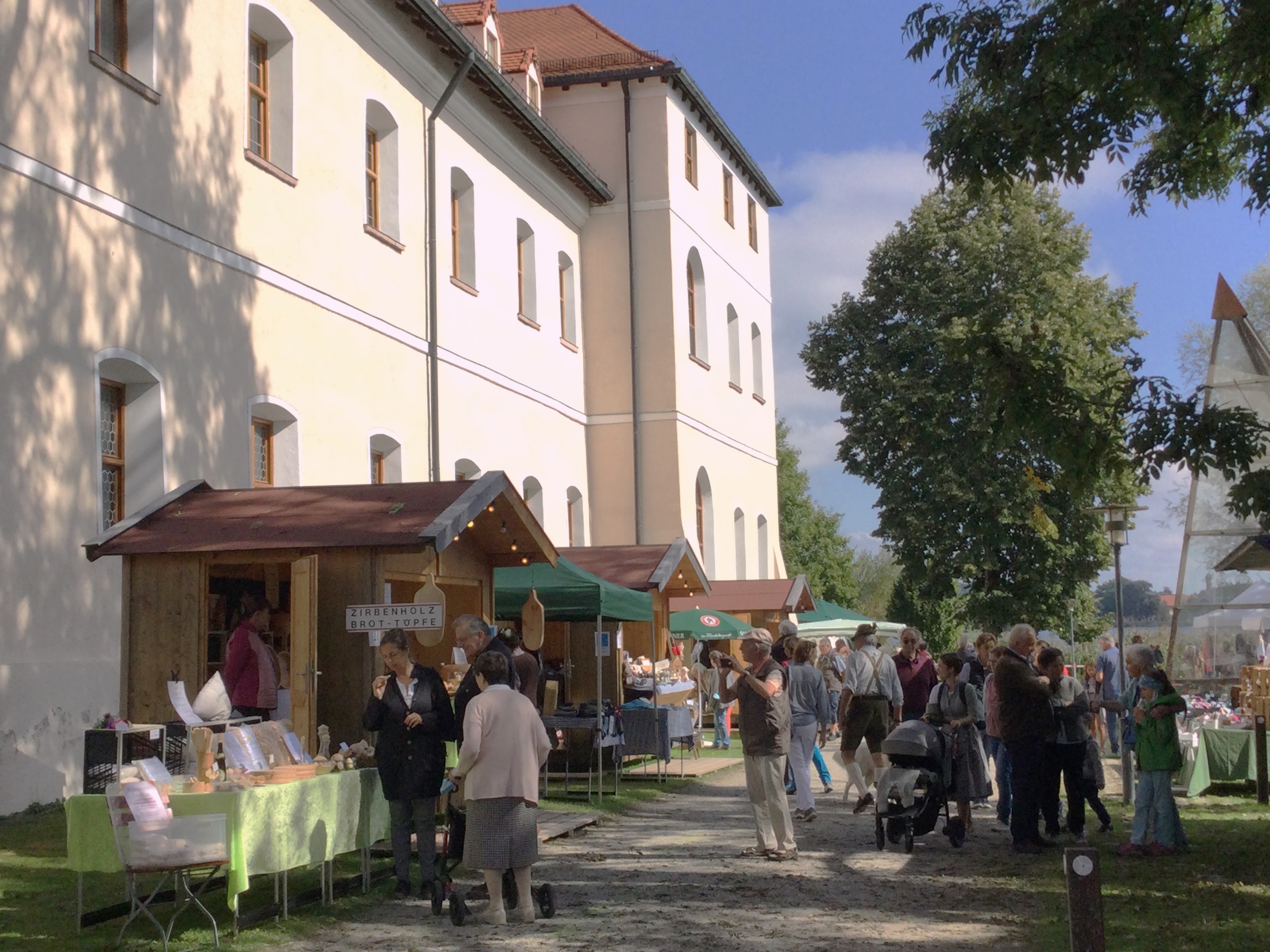 Buntes Treiben vor den Hütten der Aussteller des Klösterlichen Marktes bei Kloster Seeon