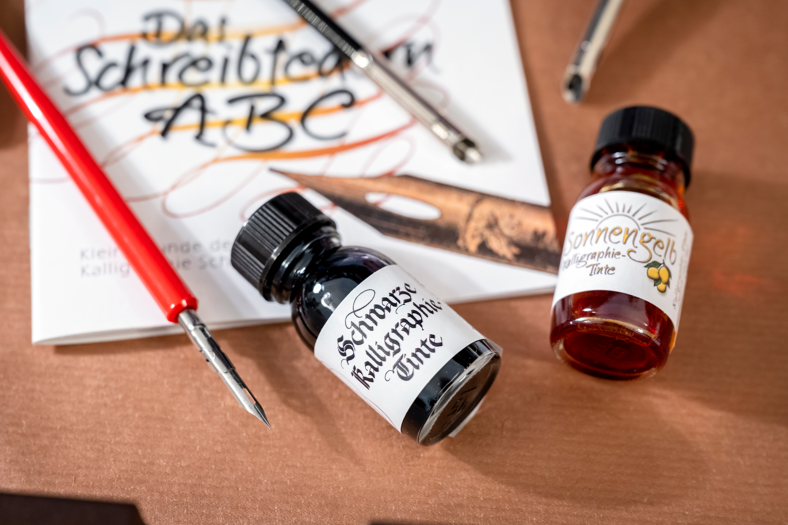 Two paint bottles with yellow and black, calligraphie quill-pen and ABC-workbook from the abbey shop at Kloster Seeon