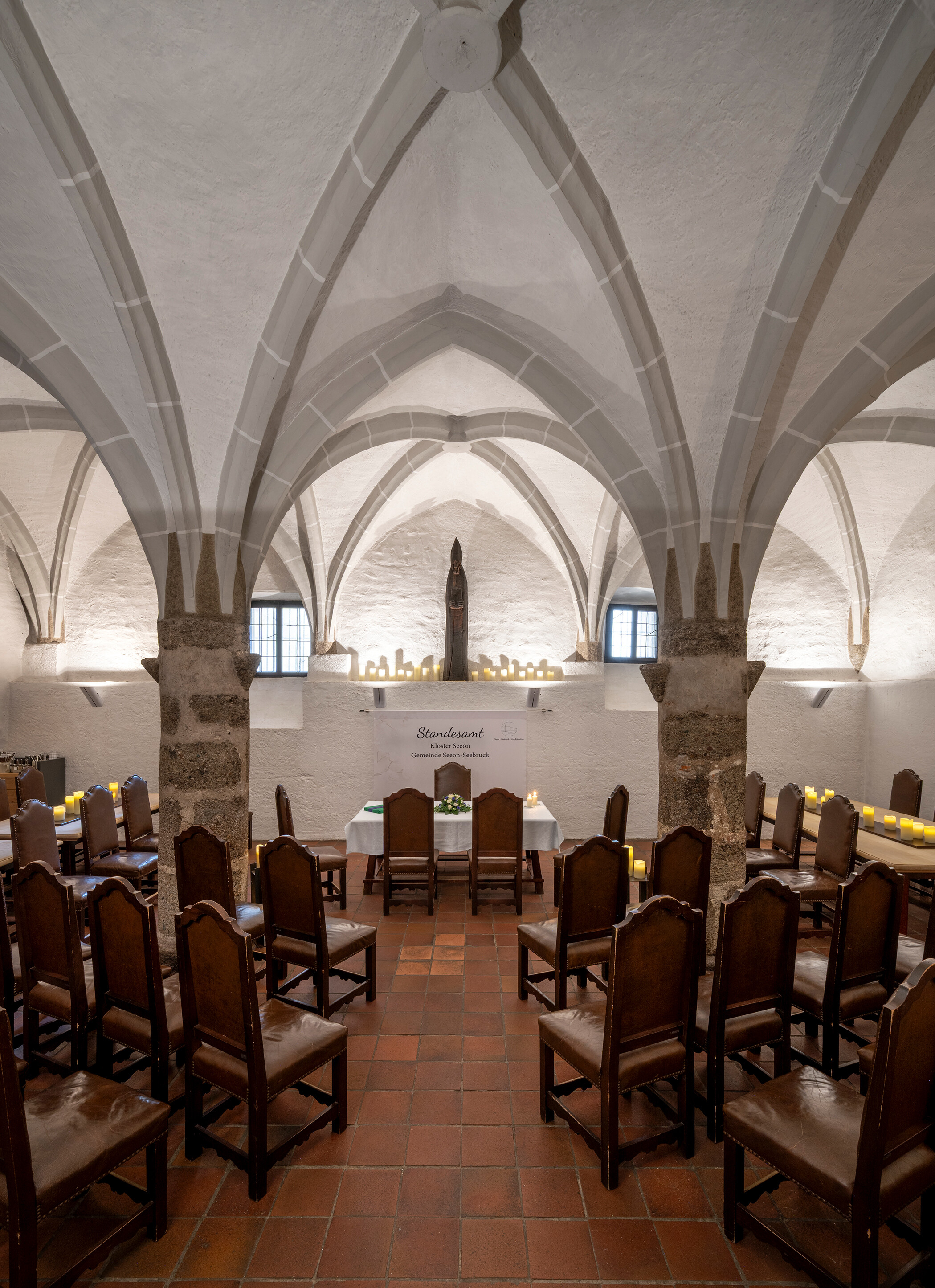 Ein Raum mit drei Steins&auml;ulen in der Mitte, dar&uuml;ber ein gotisches Netzgew&ouml;lbe, farblich hellgrau abgesetzt von den wei&szlig;en W&auml;nden: Der Gotische Keller der Klostergastst&auml;tte Seeon.