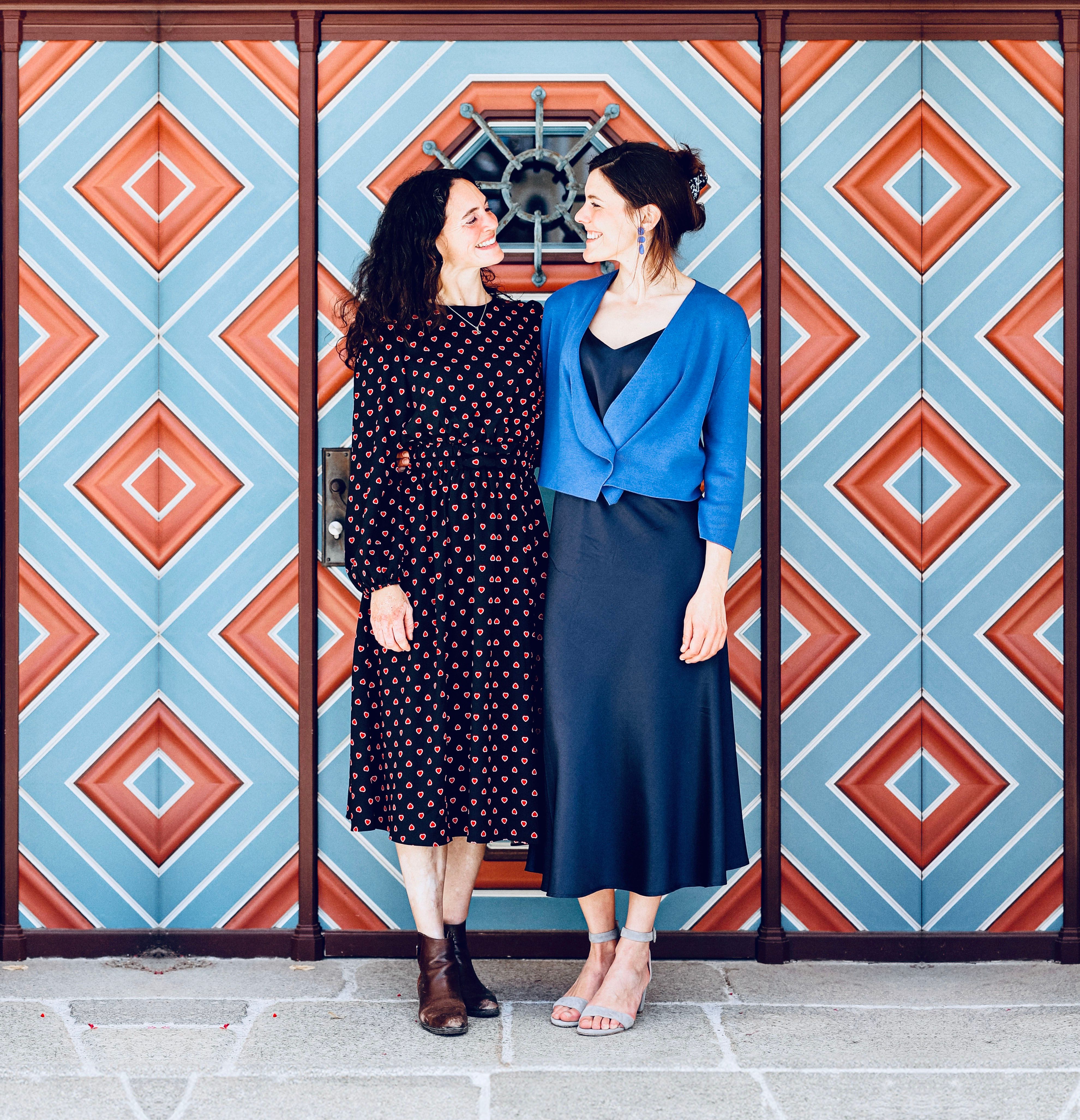 Duo Velvety mit Tessa Catchpole und Lucia Holzer steht vor einer blau-roten Wand.
