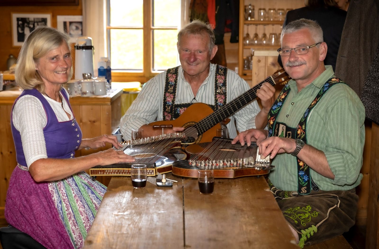 Hanni und Franz Apfel sowie Klaus Stumpf, sitzend am Tisch mit Zither und Gitarre